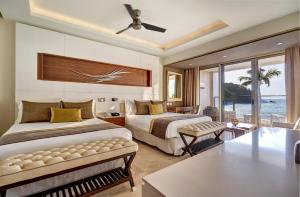 a bedroom with two beds and a view of the ocean at Royalton Saint Lucia, An Autograph Collection All-Inclusive Resort in Gros Islet