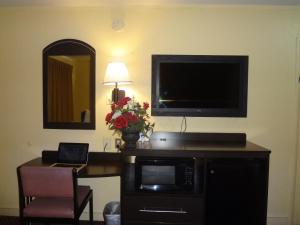 a room with a desk with a microwave and a television at Americas Best Value Inn - Goldsboro in Goldsboro