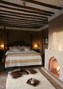 a bedroom with a large bed and a fireplace at Dar Beija in Marrakesh