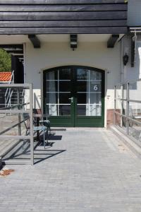 una puerta delantera de una casa con una puerta verde en Strandhotel Dennenbos, en Oostkapelle