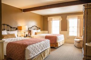 a hotel room with two beds and a chair at Lajitas Golf Resort in Terlingua