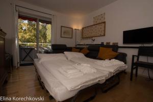 ein großes Bett im Wohnzimmer mit Sofa in der Unterkunft bahnhofsnahe, ruhige und sonnige 2 Zimmerwohnung im Dichterviertel (bis 4 Personen) in Wiesbaden