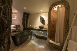 a bathroom with a black tub and a sink at Nayara Hangaroa in Hanga Roa