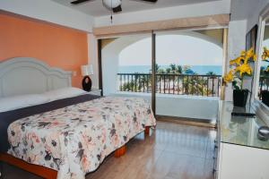 1 dormitorio con 1 cama y balcón en ENNA INN IXTAPA DEPARTAMENTOS ViSTA AL MAR, en Ixtapa