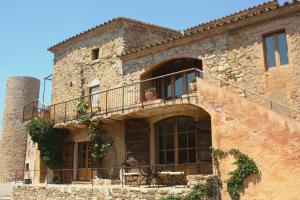 an old stone building with a balcony and a table at Hotel del Teatre - Adults Only in Regencós