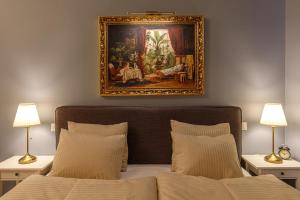 a bedroom with a painting above a bed at Tabán Art Appartmann in Budapest