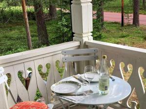 a table with two glasses and a bottle on a porch at Holiday home RÖRBÄCKSNÄS in Rörbäcksnäs