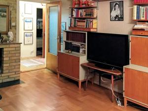 a living room with a tv and a desk with a television at Holiday home RÖRBÄCKSNÄS in Rörbäcksnäs
