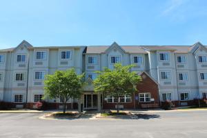 un gran edificio azul con árboles delante de él en Microtel Inn and Suites Montgomery en Montgomery