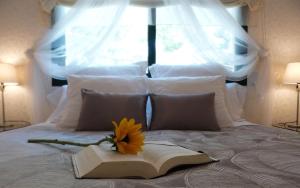 a book with a flower on top of it on a bed at Ca la Carmeta in Cunit