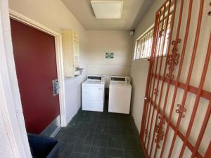 pasillo de una habitación pequeña con lavadora y secadora en Budget Inn of Hayward, en Hayward