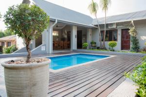 a villa with a swimming pool and a house at Vinique Guesthouse in Nelspruit