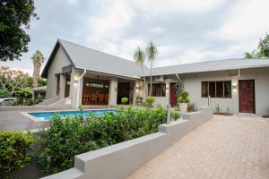 a house with a swimming pool in front of it at Vinique Guesthouse in Nelspruit