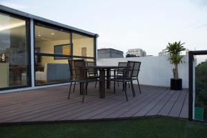 a wooden deck with a table and chairs on a balcony at Suites Lerma 205 in Mexico City