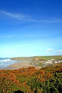 a view of the ocean and a sandy beach at Tregurrian Villas in Newquay