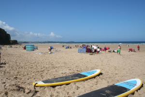 two surfboards in the sand on a beach at Tregurrian Villas in Newquay