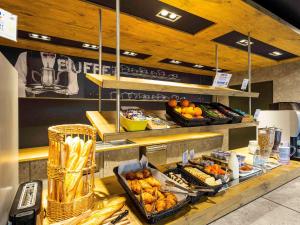 a buffet line with food on display in a restaurant at ibis budget Angoulême Nord in Champniers