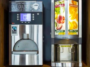 a coffee machine next to a box of orange juice at ibis budget Angoulême Nord in Champniers