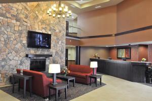 eine Lobby mit einem Kamin und einem TV an einer Steinmauer in der Unterkunft Lakeside Hotel Casino in Osceola