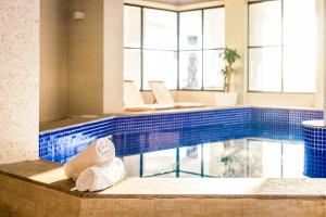 a pool with two rolled towels in a hotel bathroom at Hotel D'sintra in Balneário Camboriú