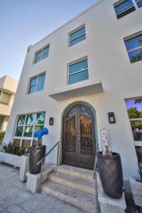 uma casa branca com uma porta preta em Sea Breeze em Miami Beach