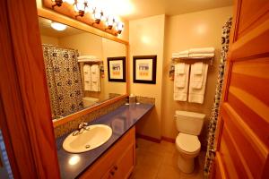 a bathroom with a sink and a toilet and a mirror at Inn at Cape Kiwanda in Pacific City