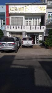 dwa samochody zaparkowane na parkingu przed hotelem w obiekcie Hotel Cát Tường w mieście La Gi