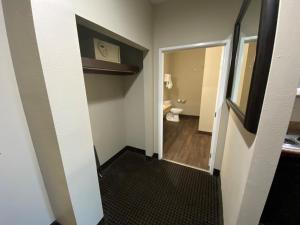 a hallway with a bathroom with a toilet and a mirror at Baymont by Wyndham Colorado Springs in Colorado Springs +29 photos