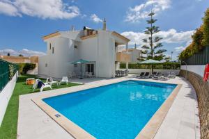 a swimming pool in front of a villa at Villas Mar e Brisa in Albufeira