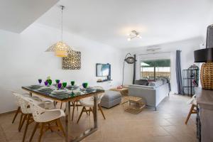 a dining room and living room with a table and chairs at Villas Mar e Brisa in Albufeira