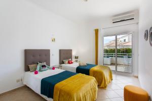 two beds in a room with a balcony at Villas Mar e Brisa in Albufeira +72 photos