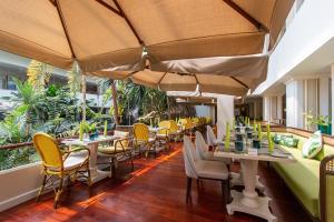 a restaurant with tables and chairs and umbrellas at Dusit Thani Pattaya in North Pattaya