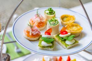 a white plate topped with different types of sandwiches at Dusit Thani Pattaya - SHA Extra Plus in North Pattaya