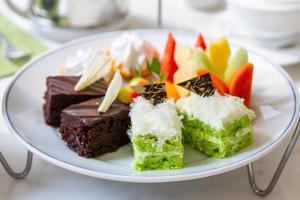 a plate of chocolate desserts and fruit on a table at Dusit Thani Pattaya in North Pattaya