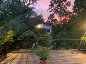 a wooden deck with a house in the background at Hostal Hilltop Capurgana in Capurganá