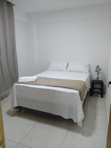 um quarto branco com uma cama grande num quarto em Jockey Family Chamonix 2 em Vila Velha