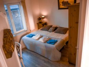 Un dormitorio con una cama con toallas azules. en Hotel / Pension Villa Tanahlot, en Zandvoort