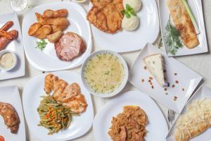 una mesa con platos blancos de comida. en Pension Arena, en Cluj-Napoca