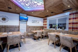 a dining room with wooden tables and chairs at Hotel Garni Siegmundshof - inclusive Joker Card im Sommer in Saalbach-Hinterglemm