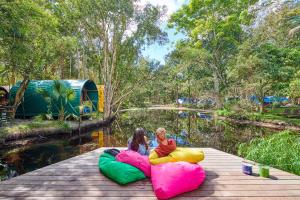 dos niños están sentados sobre inflables en un muelle en Arts Factory by Nomads en Byron Bay