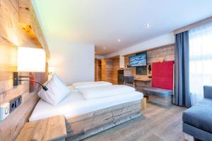 a large white bed in a room with a large window at Hotel Garni Siegmundshof in Saalbach-Hinterglemm