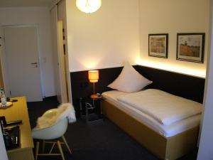 a bedroom with a bed and a desk and a chair at Haus Katharina Hotel garni in Bad Steben