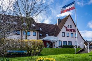 a hotel with a flag in front of it at Schlei Hotel in Kappeln