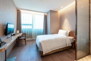 Postel nebo postele na pokoji v ubytování Auto City Ruili Hotel
