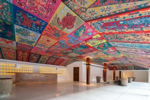 a room with a ceiling covered in colorful art at Cinnamon Bentota Beach - Signature Selection in Bentota