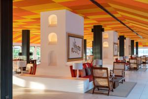 a lobby of a restaurant with chairs and tables at Cinnamon Bentota Beach - Signature Selection in Bentota
