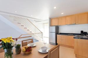 Una cocina con una mesa con un bol de fruta encima. en 1Gbps Internet Apartment The Park Choeng Mon, en Koh Samui 