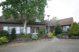 a brick house with a tree in front of it at Op de Smelen 1 - 43 m2 in Blitterswijck