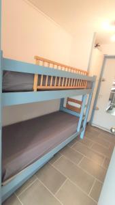 2 Etagenbetten in einem Zimmer mit Fliesenboden in der Unterkunft Le Soleillades - Plage, piscine, parking! in Palavas-les-Flots