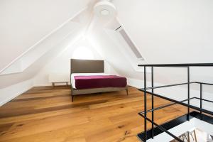 - un salon avec un lit et un escalier dans l'établissement City Center Apartments, à Kirchheim unter Teck